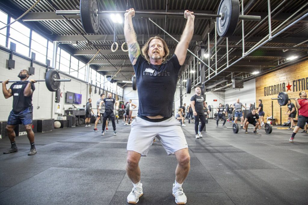 Older man learning how to Jerk at a CrossFit gym